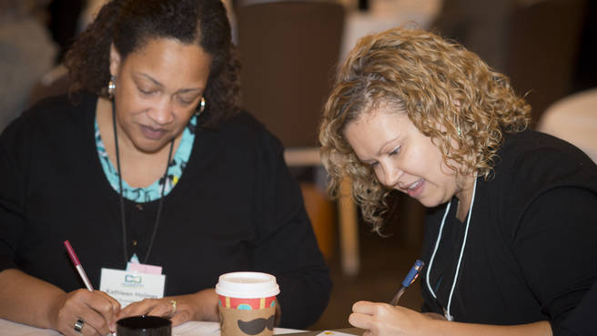 Photo of two people writing